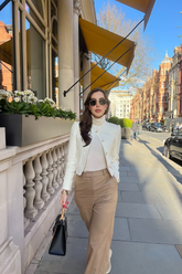 a lady wears brown pants with mily color jacket and white turtle neck top
